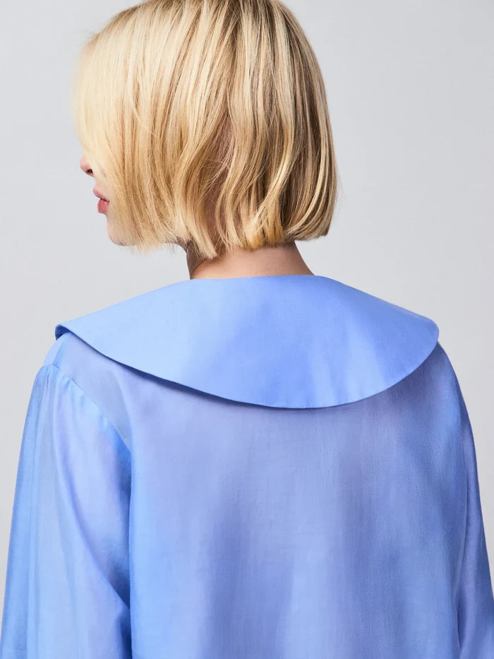 Contemporary blue sheer blouse with oversized collar, button fastening and cuff detail