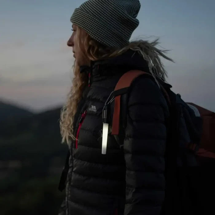 Person with a Lifesystems Intensity LED Glow Marker attached to their rucksack styrap using the carabiner at twilight