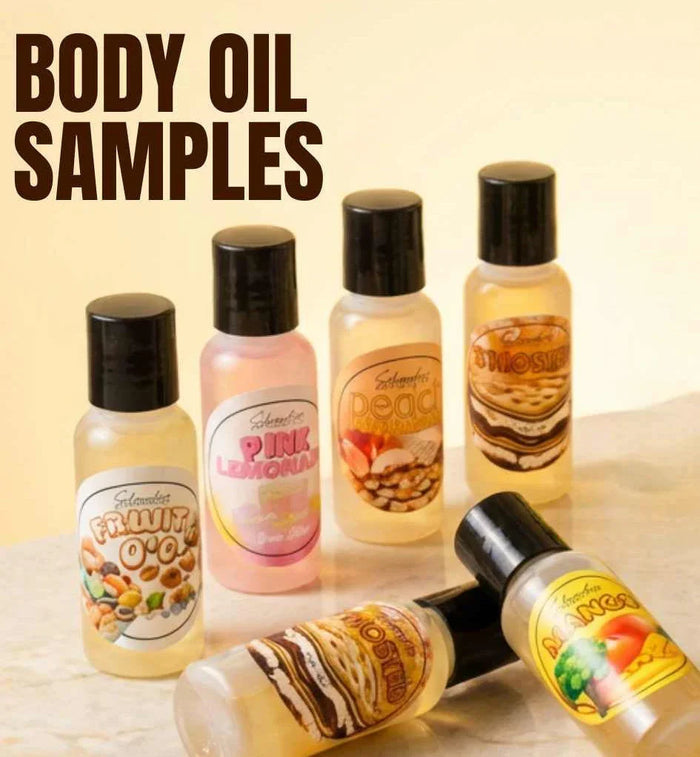 Assorted dessert-inspired scented body oil sample bottles on a marble surface