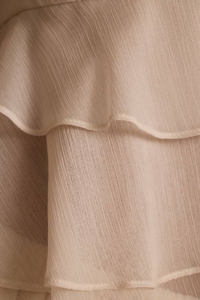Close-up of tiered ruffles and crinkle texture on the cream Alana resort wear blouse.