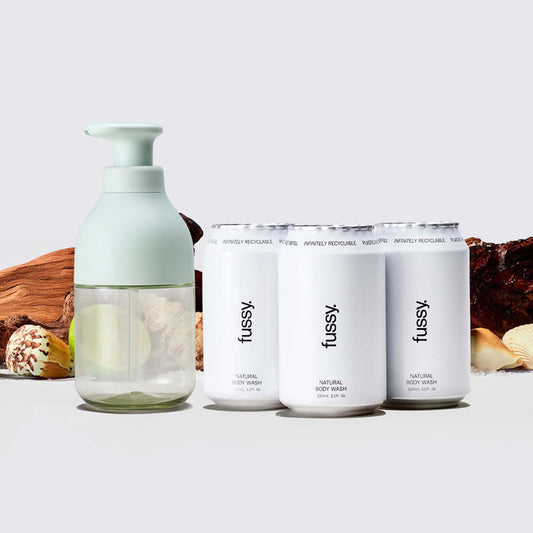 Fussy's At Sea Body Wash scent pack with Mint Green refillable bottle and three refill packs set against a backdrop of sandalwood, bergamot and sea shells.