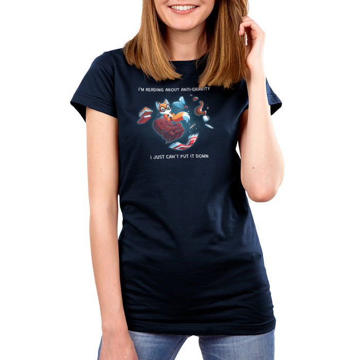 Premium Cotton T-shirt_TeeTurtle navy blue Anti-Gravity Enthusiast apparel featuring a fox wearing glasses reading a book with floating in mid-air with its living room furniture, such as a chair, rug, and lamp, with the caption, “I’m Reading About Anti-Gravity, I Just Can’t Put It Down“.