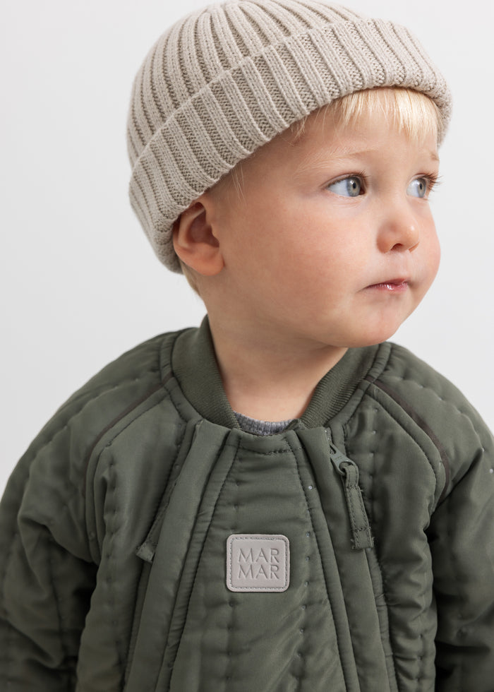 Beige striped and ribbed, tightly fitted with a turned edge.