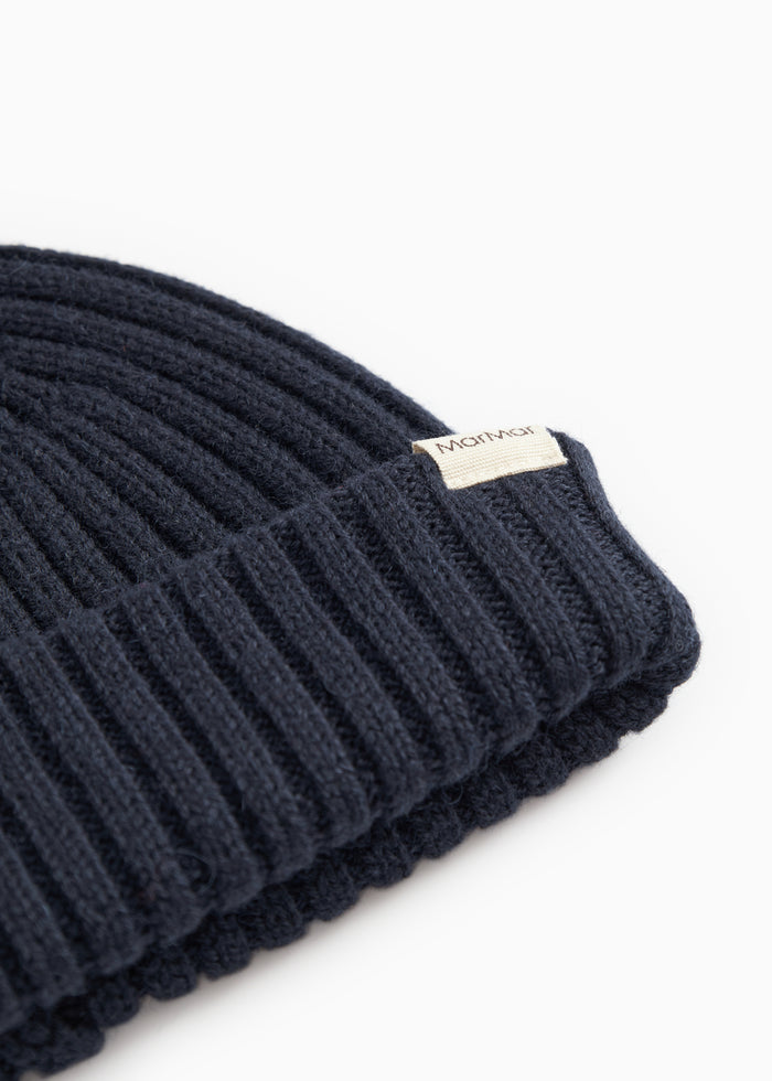 Dark blue knit hat with ribbed collar and side logo tag