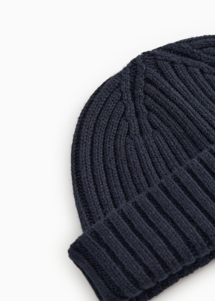 Dark blue knit hat in a tightly ribbed knit with pattern.