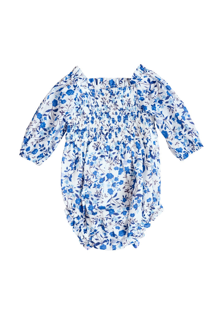 The Ivy City Co Baby Madeline Romper in Ditsy Cobalt Floral features blue and white blooms, long sleeves, an elasticized bodice, ruffled leg openings, and a gathered neckline—perfect for mom and me matching moments.