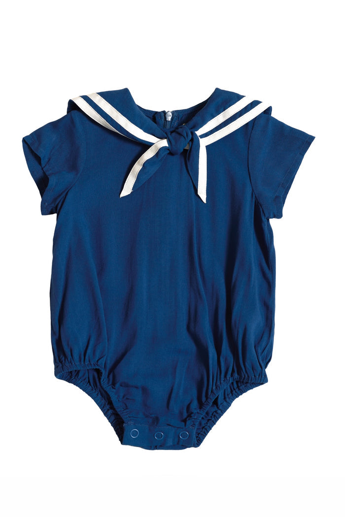 The Ivy City Co Baby Sailor Romper in Navy features short sleeves, a sailor collar with white stripes, a front tie, and snap closures—an adorable nautical outfit for your little one.