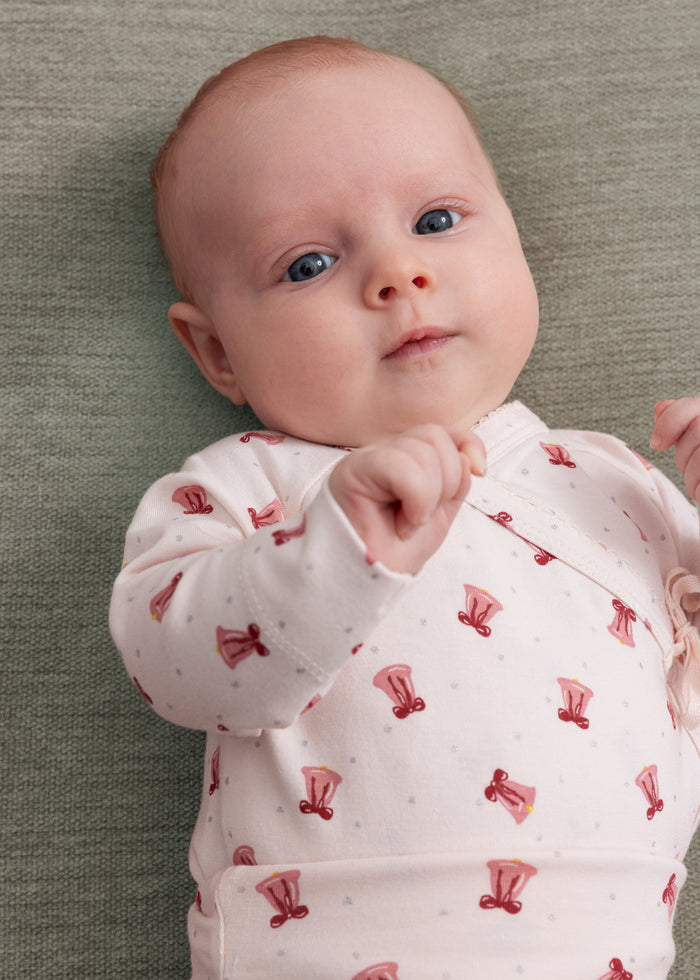 Baby in a red Christmas bell print wrap bodysuit