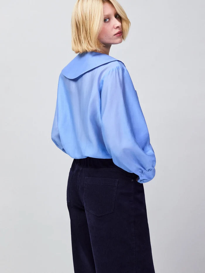Elegant blue sheer button-up blouse with front pockets and long sleeves