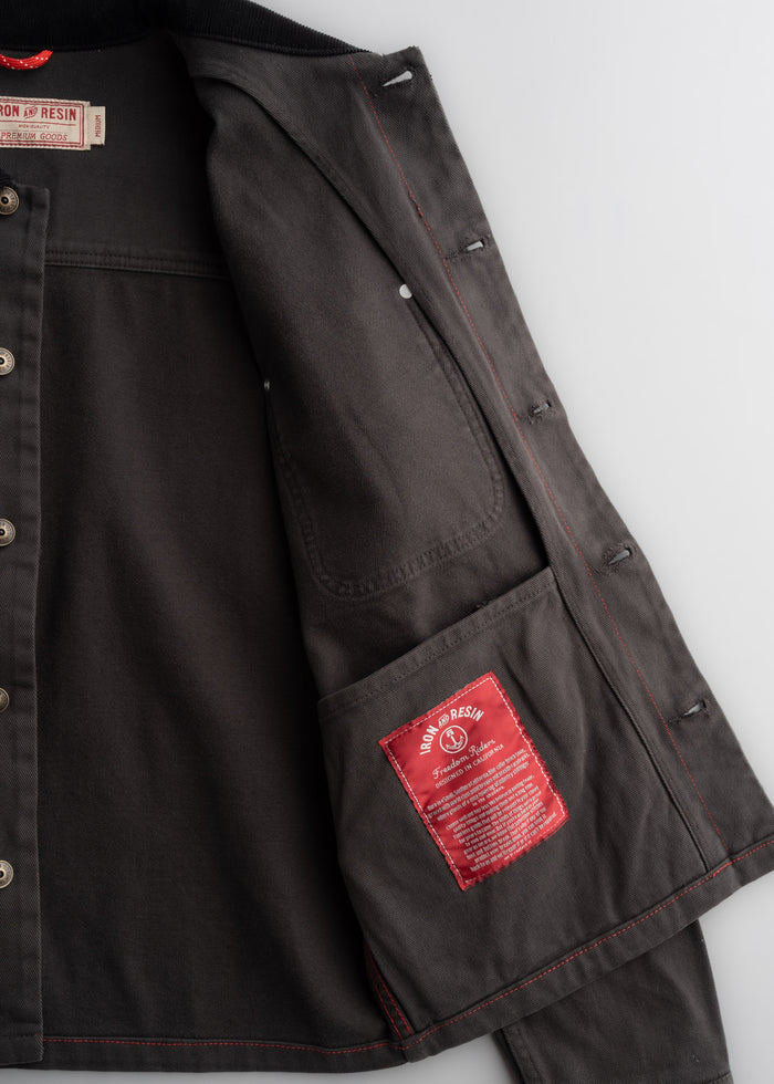 Close up of peach bull denim fabric showing interior, custom label, textured cotton weave and durable workwear construction