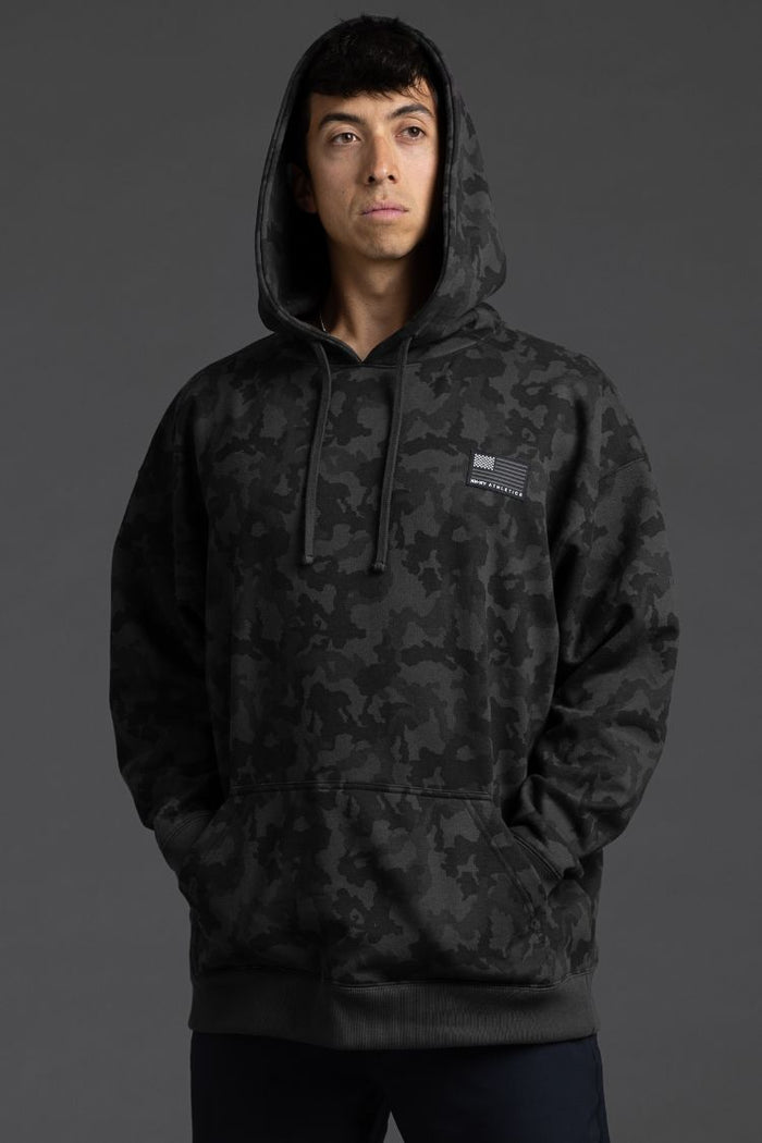 Person wearing a black camouflage hoodie on a gray background || Black Camo