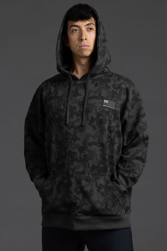 Person wearing a black camouflage hoodie on a gray background || Black Camo