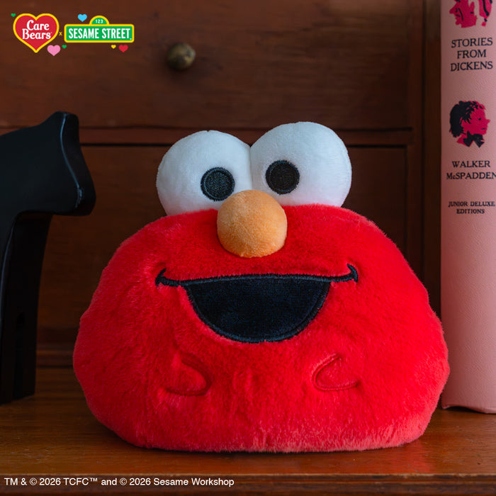 Cheer Bear & Elmo 4" Reversible Plushie on a bookshelf