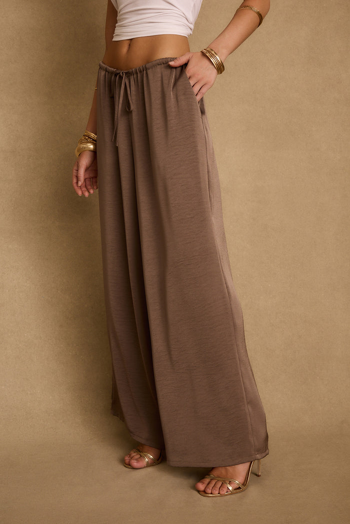 Taupe satin wide-leg drawstring pants styled with a white tank and gold heels.