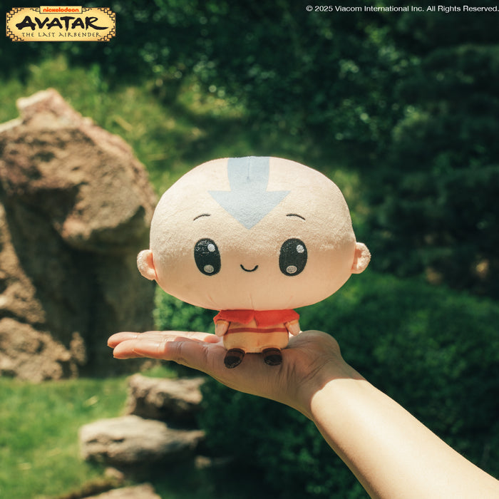 Cloudheads: 5" Aang being held up by a hand with large mossy rocks and trees in the background