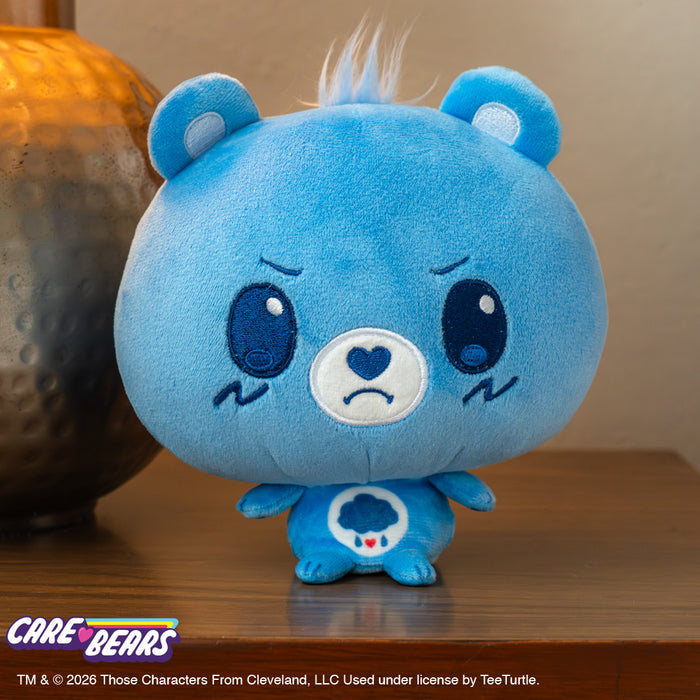 Care Bears Grumpy Bear Cloudhead sitting on a wooden desk next to a lamp