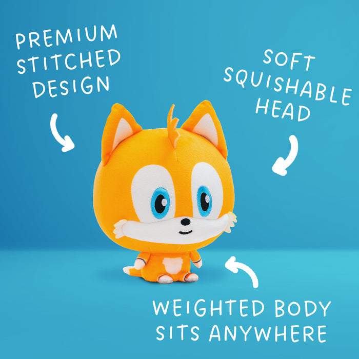 Tails Cloudhead, a plushie with a big head and a tiny body. He has a little smile on his face. Around him are arrows and the text "premium stitched design," "soft squishable head" and "weighted body sits anywhere."