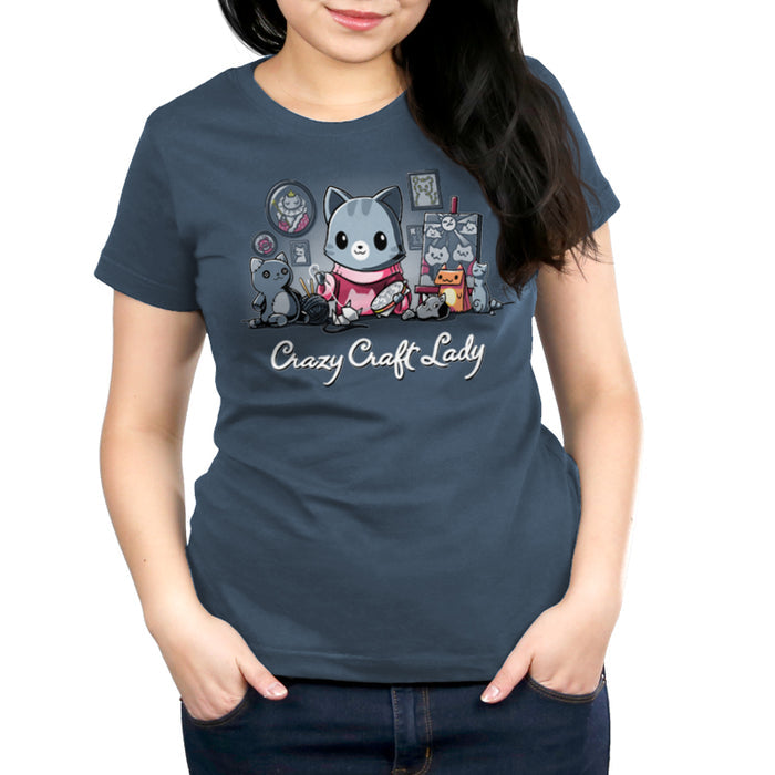 Premium Cotton T-shirt_TeeTurtle denim blue Crazy Craft Lady apparel featuring a cat happily sewing, surrounded by cat themed craft projects. Caption reads, "crazy craft lady".