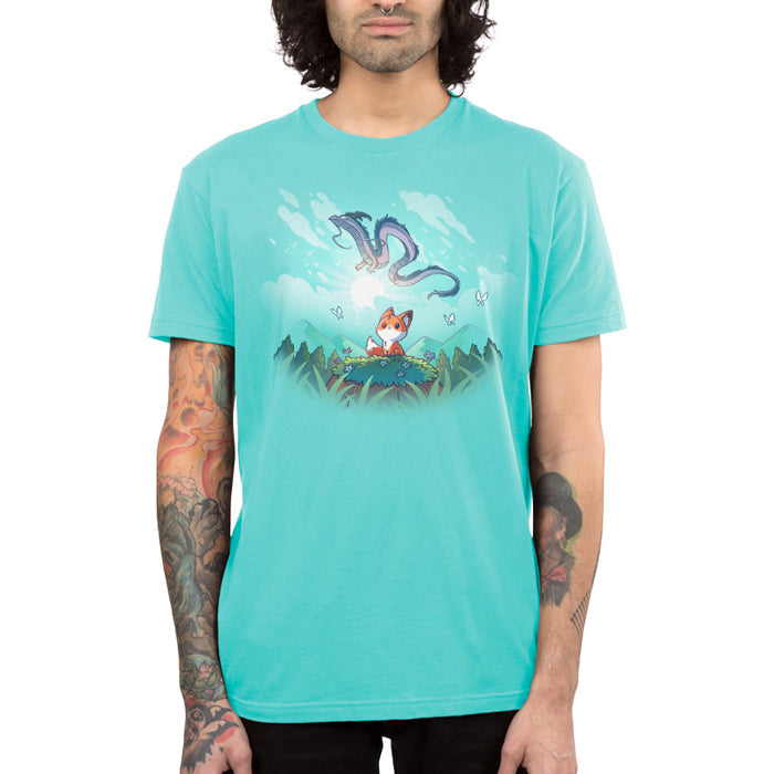 Premium Cotton T-shirt_TeeTurtle Caribbean blue Dragon Daydreams apparel featuring a fox in a mountainous forest looking up at a dragon flying in the sky.