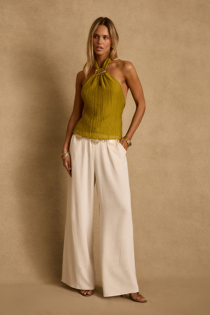 Model wearing the 12th Tribe Elio Chartreuse Halter Top in vibrant chartreuse, featuring a halter neckline and cropped silhouette, styled with skirts or tailored pants for festivals, brunches, weddings, and statement summer looks.