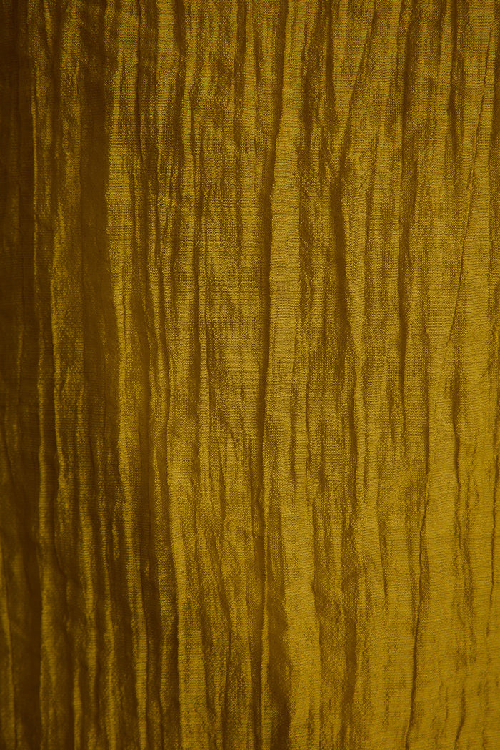Close-up of the Elio halter top's crinkled chartreuse fabric, showing its textured flowy weave.