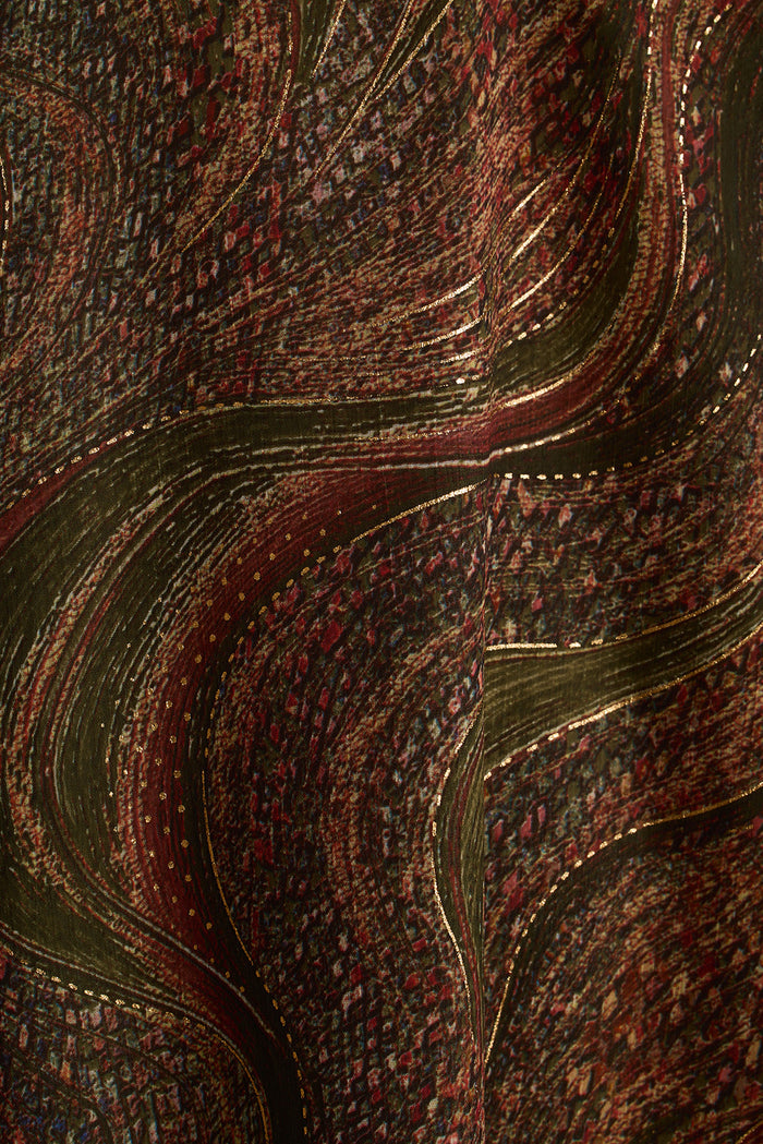 Close-up of paisley print fabric in olive and wine tones with gold lurex threading.