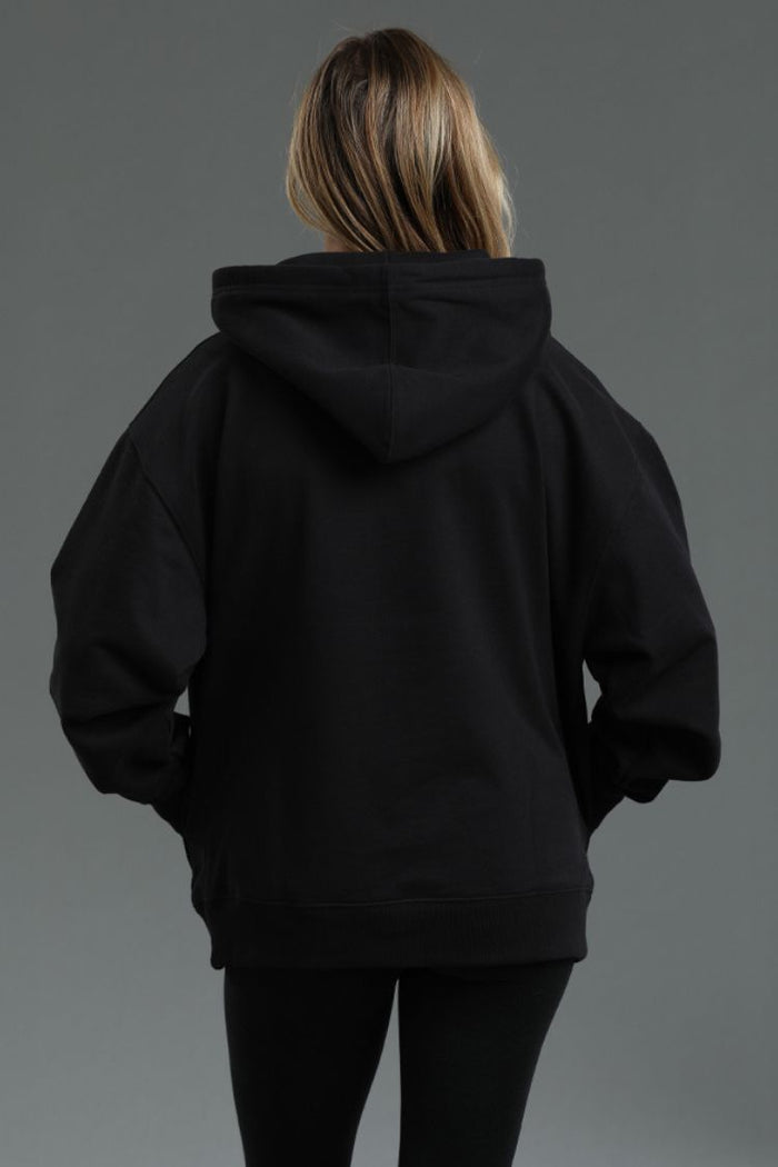 Person wearing a black hoodie against a gray background || Black
