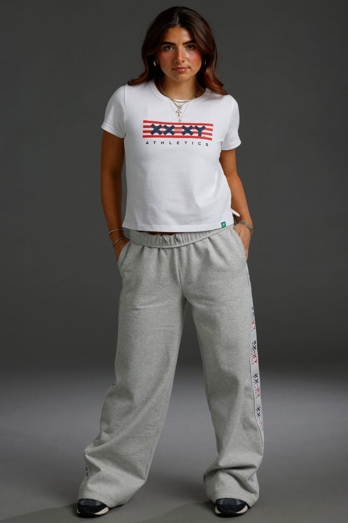 Person wearing a white t-shirt with a logo and gray sweatpants || Light Heather Gray