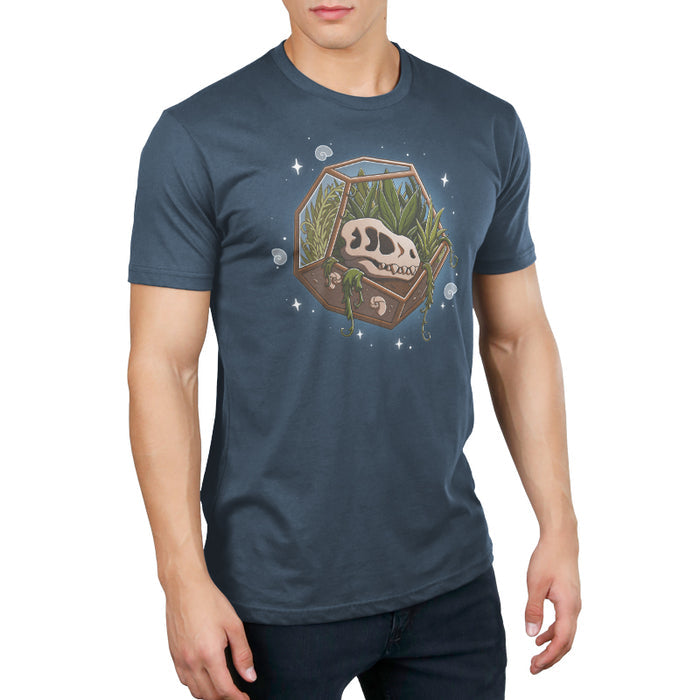 Premium Cotton T-shirt_TeeTurtle Flora Fossils denim blue t-shirt featuring an illustration of a skull in a hexagonal glass terrarium with various plants growing inside, surrounded by small stars and swirls.