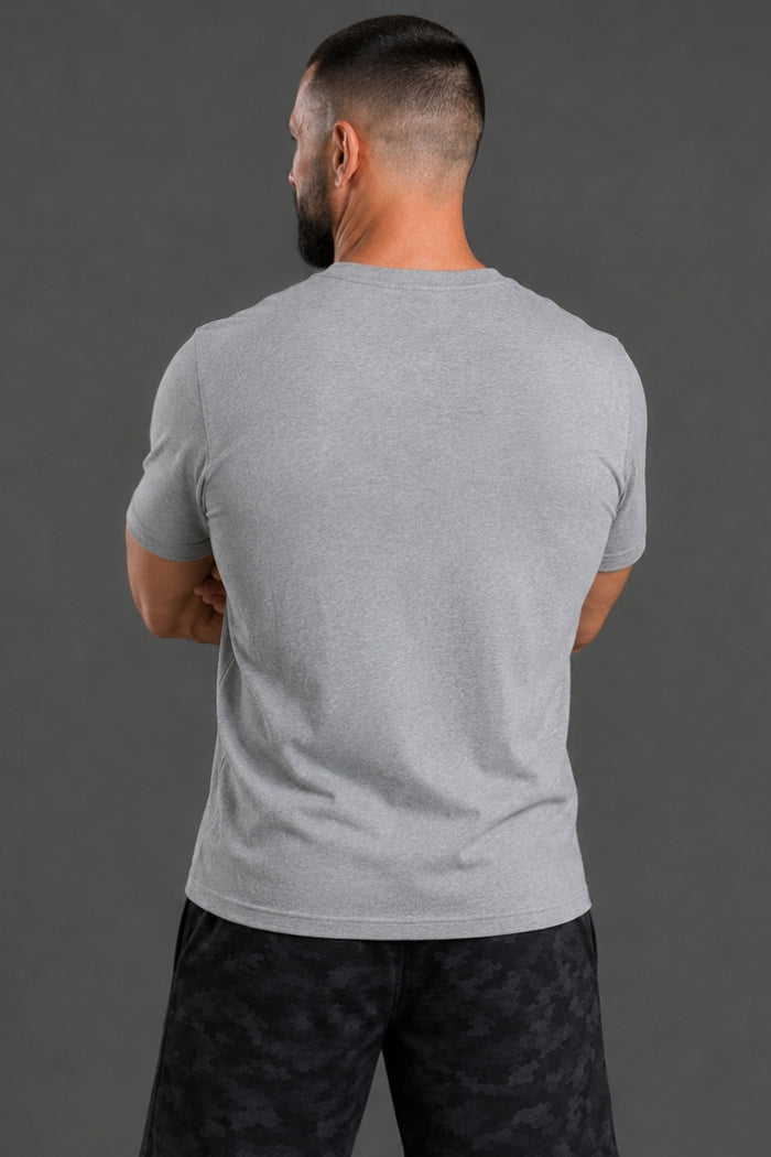 Man wearing a gray t-shirt and black patterned pants against a gray background || Light Heather Gray