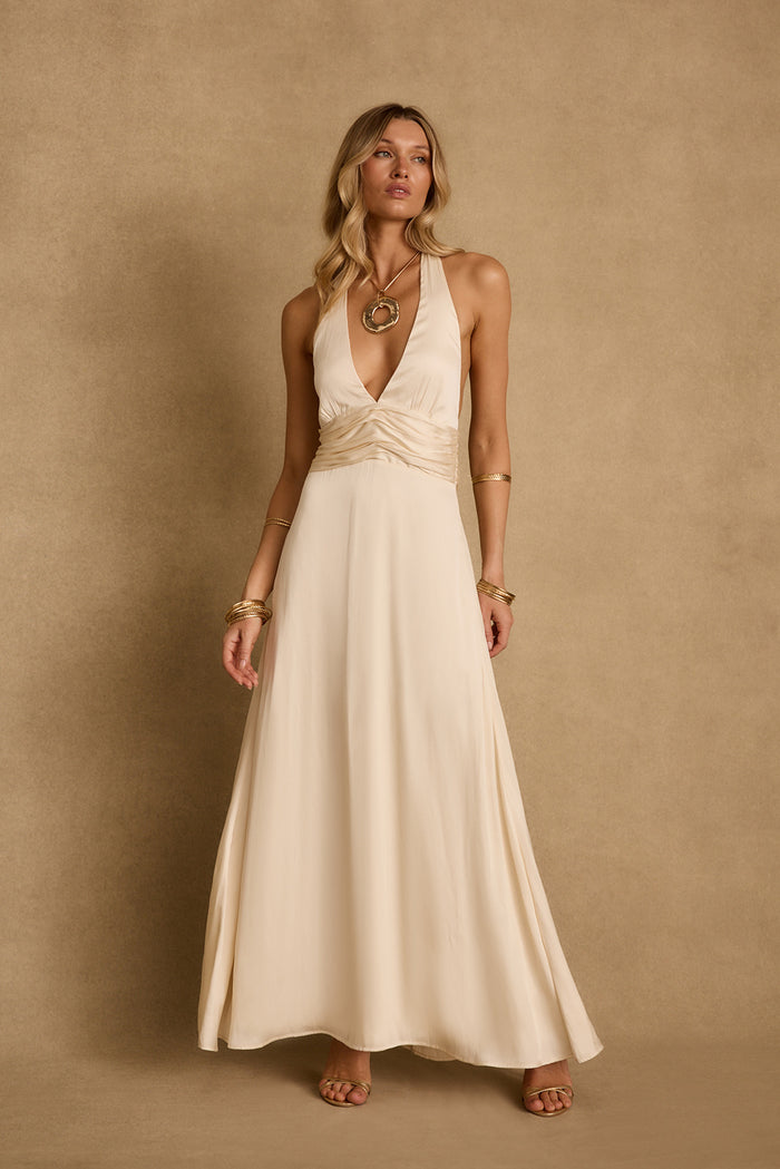 Cream satin halter maxi dress with ruched waist, styled with gold bangles and sandals.