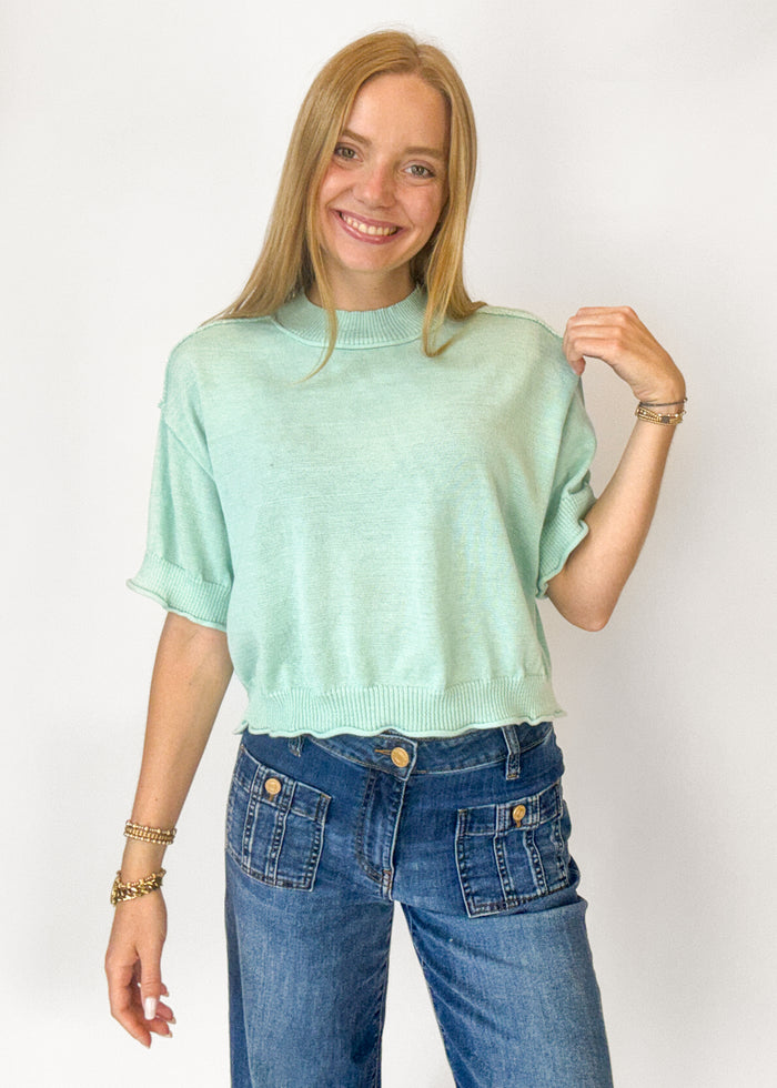 Woman wearing a mint colored short sleeve sweater