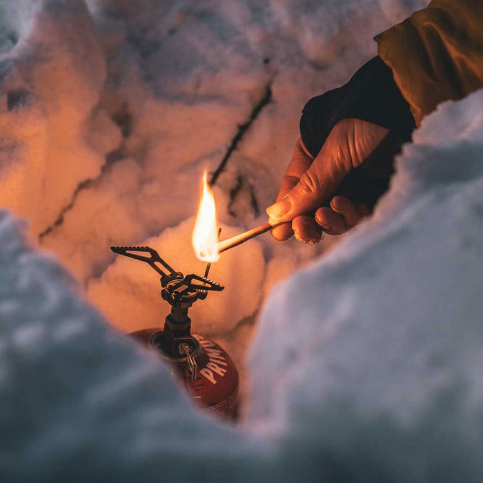 Using a Lifesystems stormproof refill match to light a primus camp stove in the snow