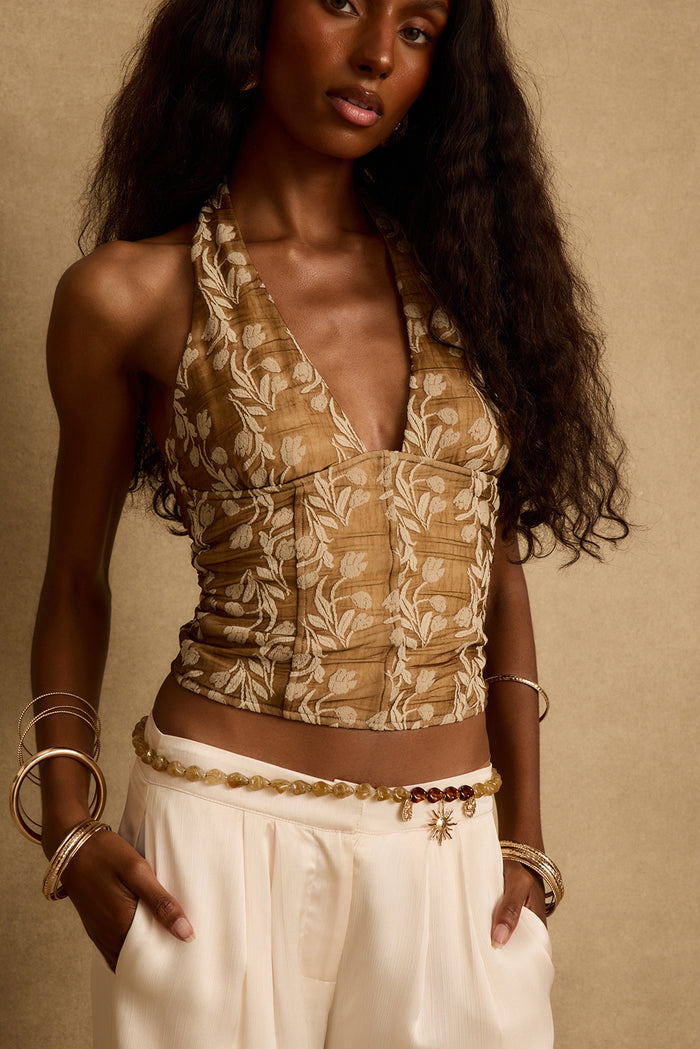 Mocha floral halter top with deep v neckline, styled with cream trousers and gold bangles.