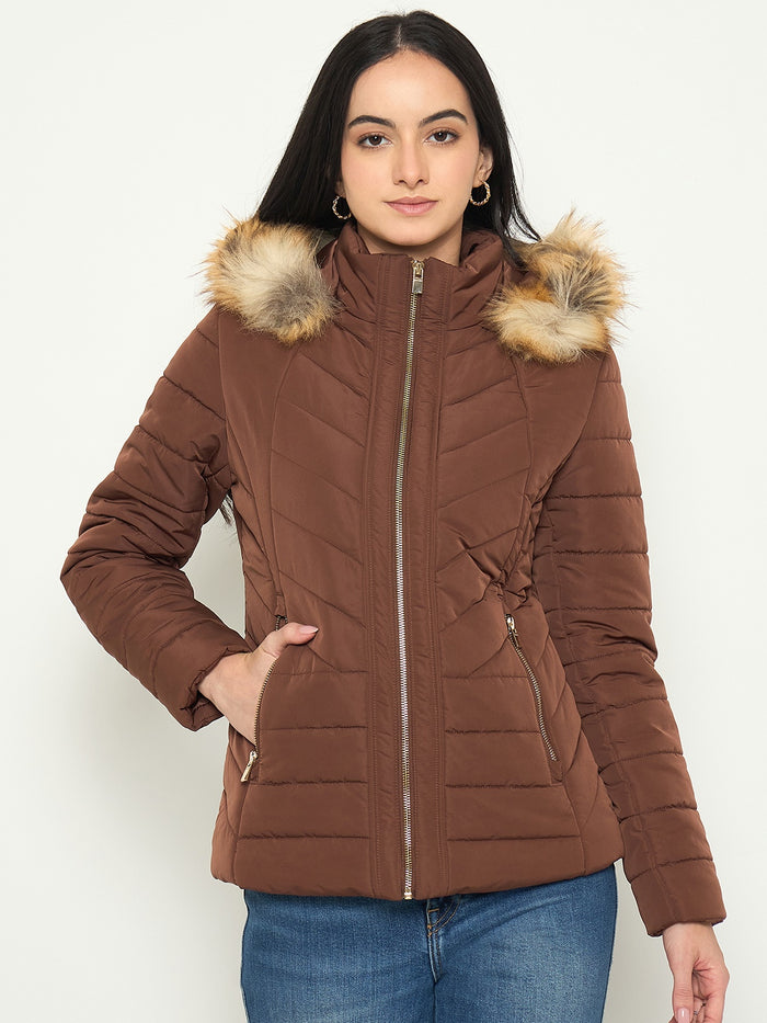 Woman wearing a brown puffer jacket with fur hood on a white background
