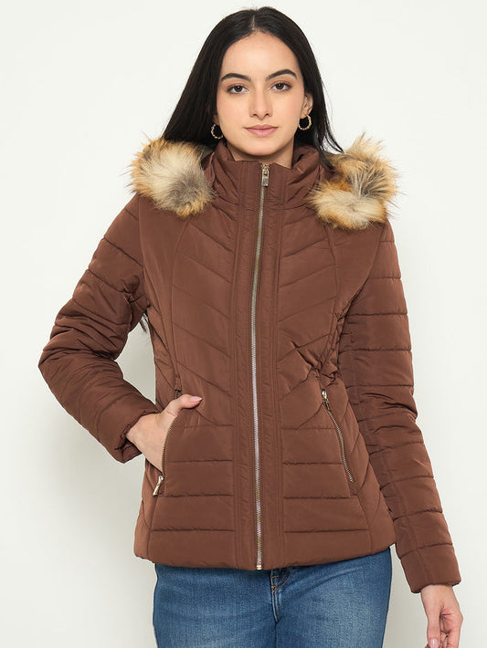 Woman wearing a brown puffer jacket with fur hood on a white background