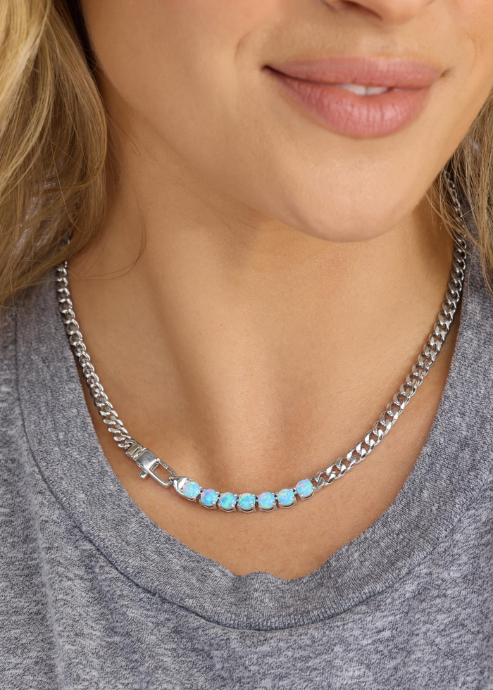 Woman wearing a silver chain necklace with seven opal stones