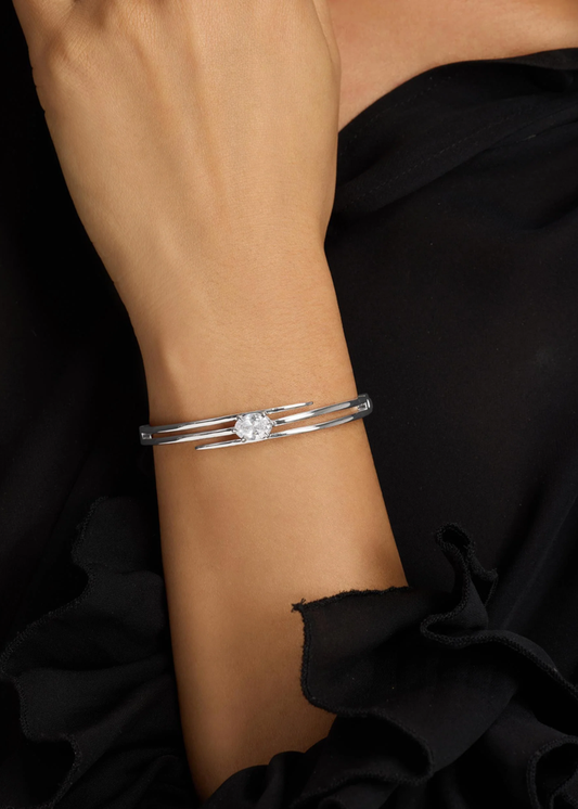 Woman wearing a silver lasso cuff bracelet with a diamond stud