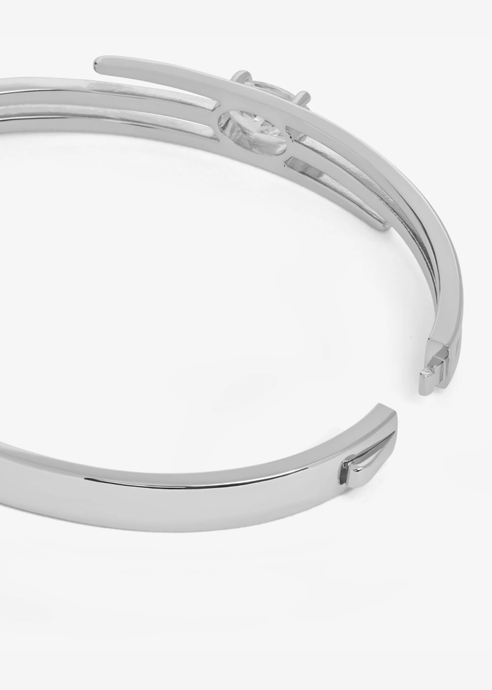 Close up of the clasp of a silver lasso cuff bracelet with a diamond stud