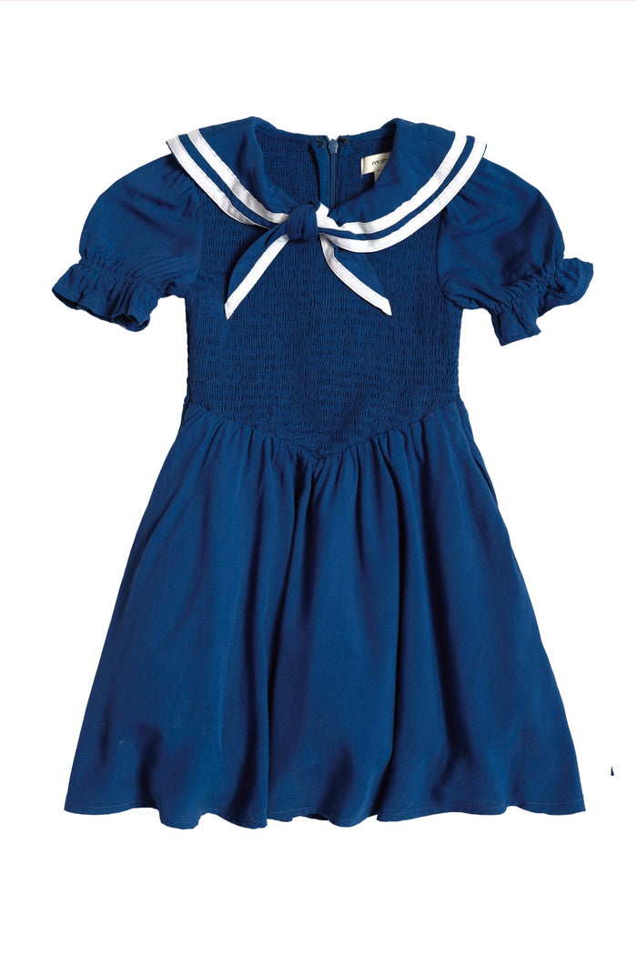 The Mini Alice Dress in Navy by Ivy City Co features a smocked bodice, ruffled sleeves, and a white sailor-style collar with a bow and stripes—perfect for Mom and Me matching moments.