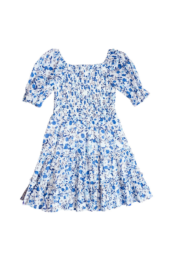 The Mini Madeline Dress in Ditsy Cobalt Floral by Ivy City Co features blue and white ditsy florals, short puff sleeves, square neckline, smocked bodice, and a tiered ruffled skirt—ideal for Mom and Me matching outfits. Shown on a white background.