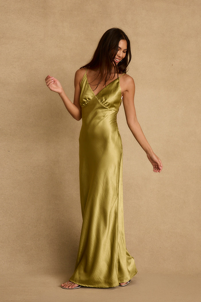 Chartreuse satin maxi dress with V-neckline and bias-cut skirt, styled with silver sandals.
