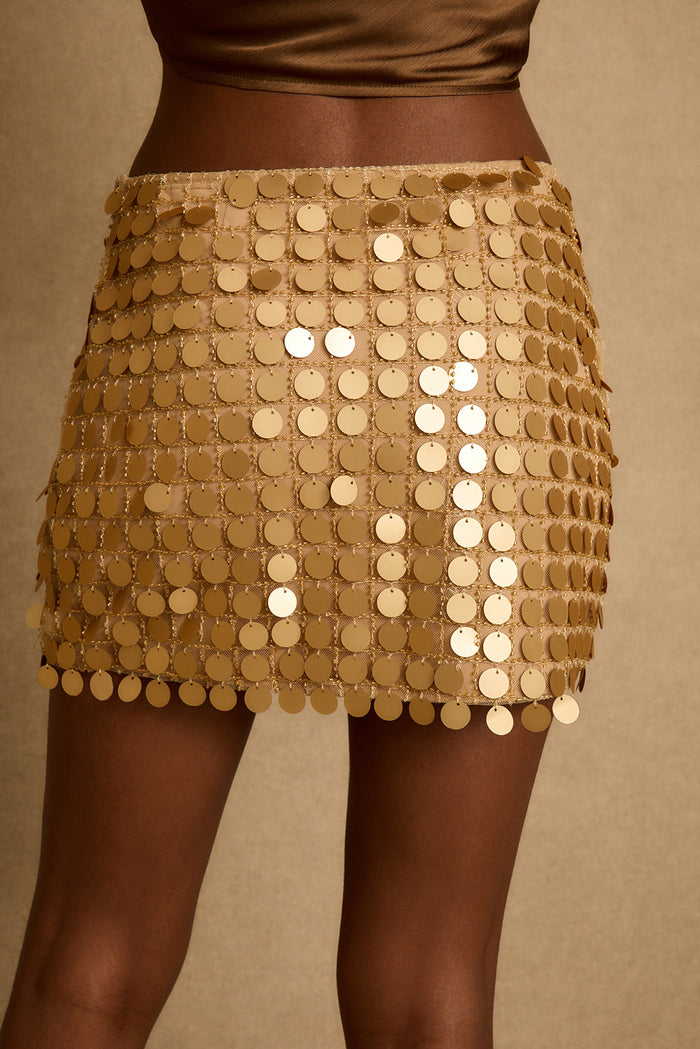 Close-up of the Miramar gold payette mini skirt, disc sequins layered over mesh.