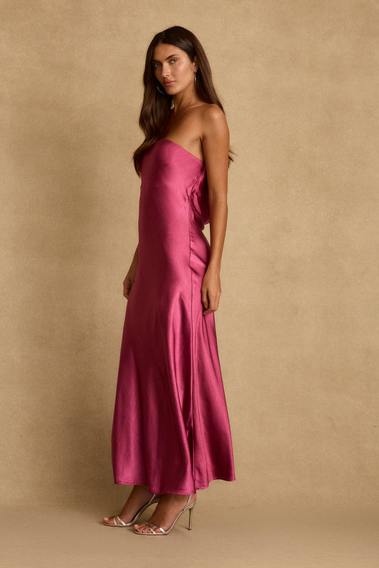 Side view of the Natalia fuschia satin strapless maxi dress with metallic heels.
