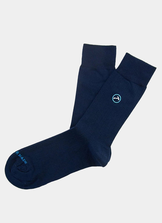 The Navy/Aqua Logo Sock is a plain navy blue pair with a small circular logo near the top and blue text on the toe, shown on a white background. Fits sizes 8-12 for versatile comfort.
