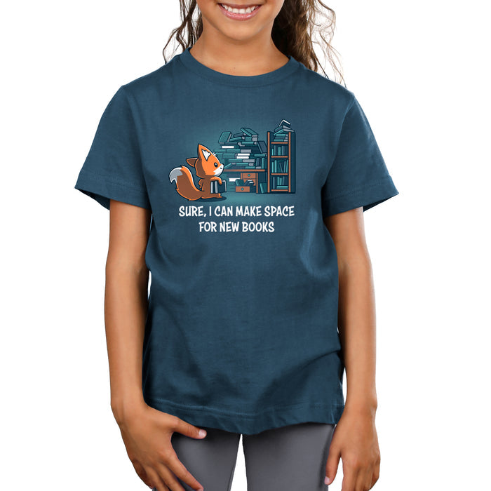 Premium Cotton T-shirt_TeeTurtle denim blue Never-Ending Bookshelf apparel featuring a fox holding a book standing in front of an overflowing book and desk with the caption, “Sure, I can Make Space for New Books“.
