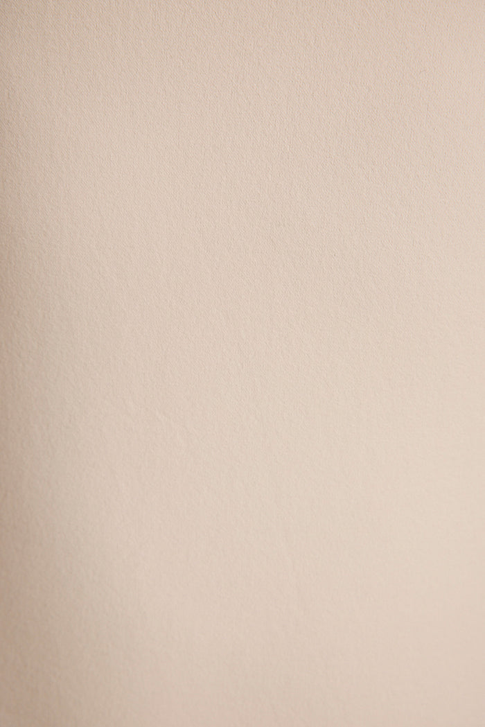 Extreme close-up of the Norma under dress fabric, showing smooth seamless cream knit.