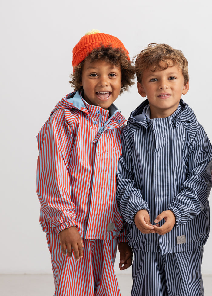 Kids raincoat with hood and leggings in red and blue stripes on model