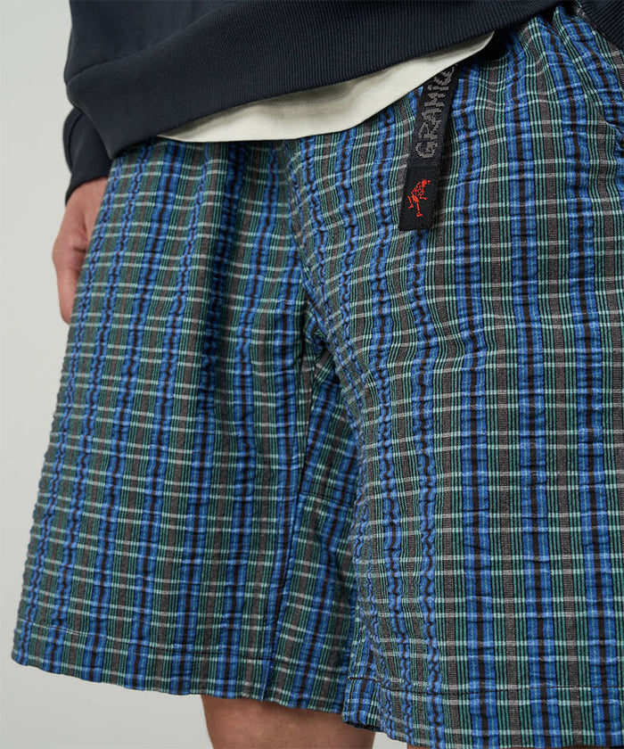 Model wearing a Gramicci blue multistripe Gramicci O.G. G-Short Seersucker Plaid against a light-tone background.