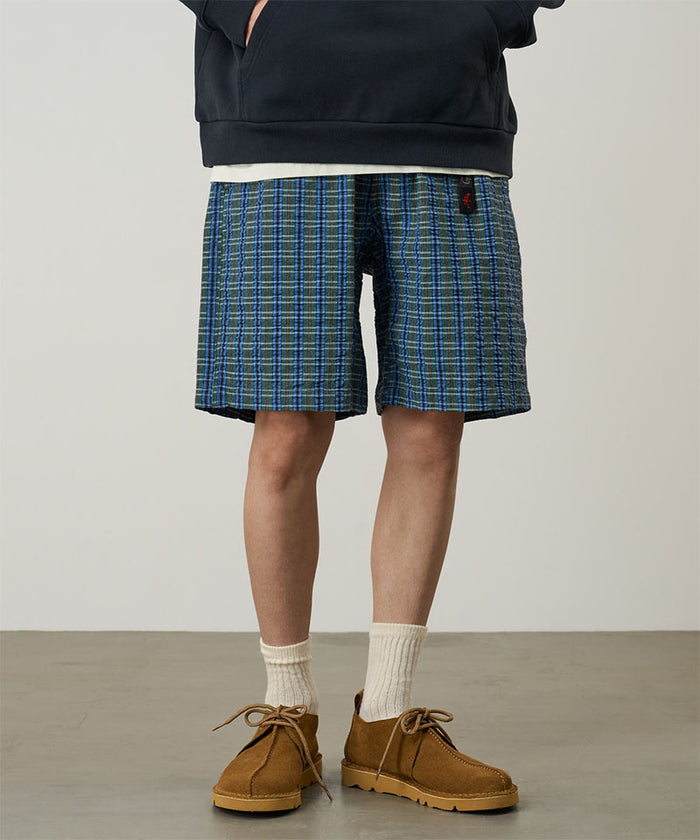 Model wearing a Gramicci blue multistripe Gramicci O.G. G-Short Seersucker Plaid against a light-tone background.